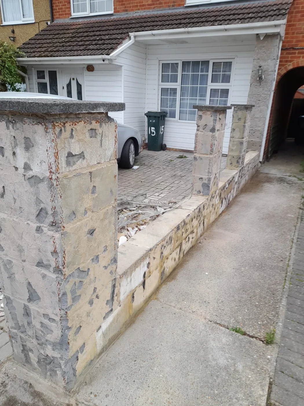 Front boundary wall — deteriorated render and old pillars
